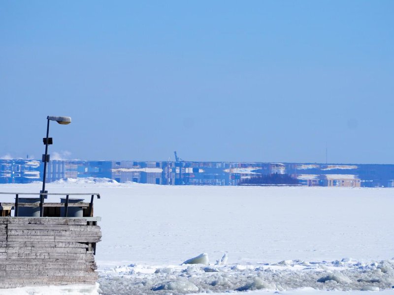 Ice shelf with a pier in the foreground, and in the distance a distorted mirage of the coast.jpg