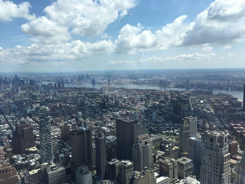 Manhattan skyline seen from above, with Hudson river in the distance, blue cloudy sky.jpg